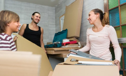 Removal team loading household items into a vehicle at the start of a booked move