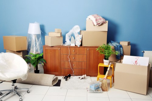 Professional movers handling furniture in a narrow West London property