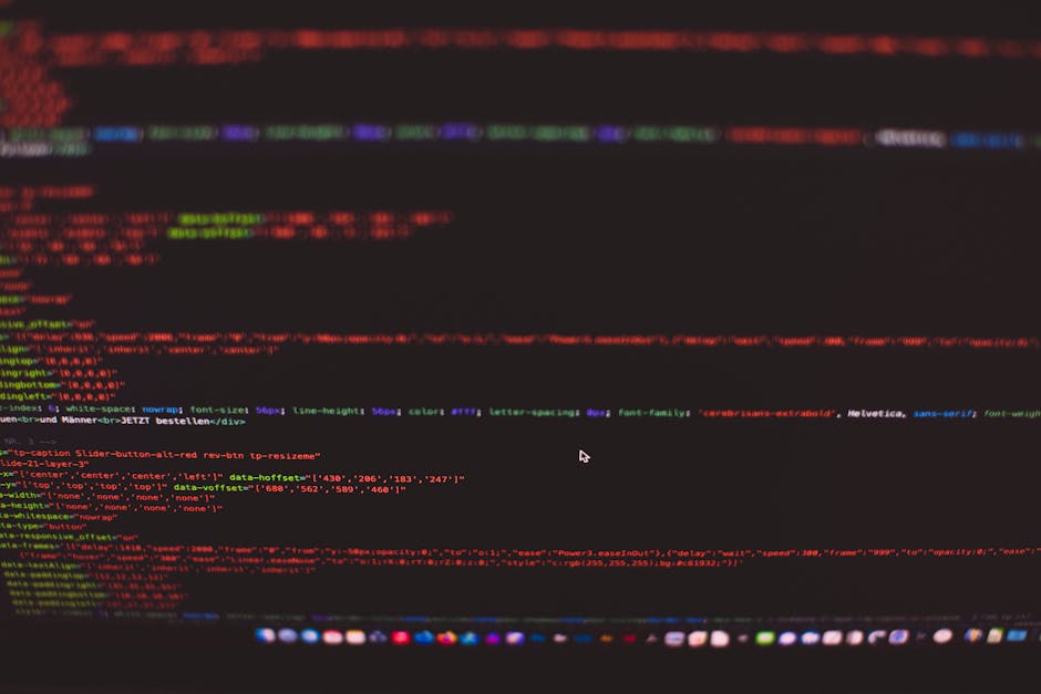 A close-up photograph of a computer screen displaying lines of code with multicoloured syntax highlights in red, green, blue, and purple on a dark background. The screen appears to be part of a home r